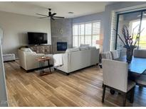 Spacious living room featuring a fireplace, ceiling fan, and dining area with lots of natural light at 19550 N Grayhawk Dr # 2023, Scottsdale, AZ 85255