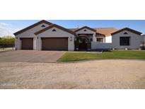 Charming single story home featuring a three car garage, manicured lawn and desert landscaping at 19880 W Desert Views Dr, Casa Grande, AZ 85122