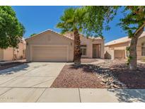 Charming single-story home featuring desert landscaping and a well-manicured lawn with a mature palm tree at 2922 N 107Th Dr, Avondale, AZ 85392