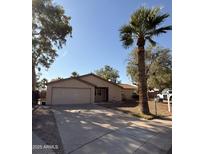Tan single-story home with a two-car garage, mature landscaping, and a spacious driveway at 3914 E Andorra Dr, Phoenix, AZ 85032