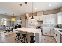 Modern kitchen features a large island with a quartz countertop, stainless steel appliances, and a dining area at 6850 E Mcdowell Rd # 29, Scottsdale, AZ 85257