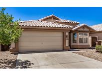 A charming single-story home with a two-car garage, desert landscaping and tile roof at 16120 N 86Th Ln, Peoria, AZ 85382