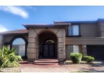 Inviting two-story home featuring an arched entry, decorative iron doors, and manicured landscaping at 1725 E Coconino Dr, Chandler, AZ 85249