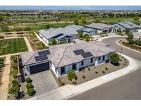 Stunning aerial view of a community featuring a home with solar panels, lush golf course and scenic surroundings at 17376 W Wildwood St, Surprise, AZ 85388