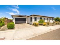 Charming single-story home with a two-car garage, brick driveway, and desert landscaping in a sunny, suburban setting at 17376 W Wildwood St, Surprise, AZ 85388