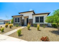 Inviting home showcasing desert landscaping, decorative stone accents, and a well-maintained walkway at 17376 W Wildwood St, Surprise, AZ 85388