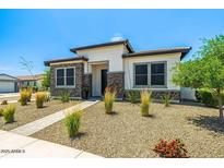 Charming single-story home featuring desert landscaping, stone accents, and a welcoming walkway to the front door at 17376 W Wildwood St, Surprise, AZ 85388