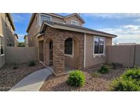 Charming two-story home featuring a beautiful stone facade, landscaped yard, and inviting walkway at 17802 N 114Th Ln, Surprise, AZ 85378
