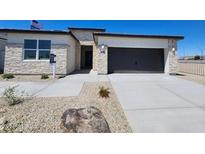 Attractive single-story home with a two-car garage and stone accents at 24105 W Flores Dr, Buckeye, AZ 85326