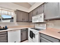 A bright kitchen features stainless steel appliances, light countertops and stylish gray cabinets at 5135 E Evergreen St # 1159, Mesa, AZ 85205