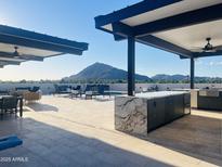 Outdoor rooftop area with a full kitchen, lounge seating, dining table, and mountain views at 6803 E Main St # 4415, Scottsdale, AZ 85251