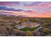 Stunning aerial view of desert estate home with custom pool, outdoor living, and colorful sunset at 7130 E Navarro Way, Scottsdale, AZ 85266