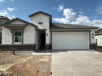 Charming single-story home featuring a two-car garage, stone accents, and low-maintenance landscaping at 7428 W Buckhorn Trl, Peoria, AZ 85383