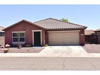 Charming single-story home with a two-car garage, xeriscaped front yard, and decorative star on the facade at 7551 W Darrel Rd, Laveen, AZ 85339