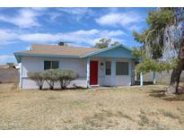 Charming single-story home featuring light blue trim, red door and a well-maintained front yard at 8802 W Cinnabar Ave, Peoria, AZ 85345
