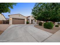 Charming single-story home with a well-manicured front yard and spacious driveway leading to a brown three-car garage at 19905 E Apricot Ln, Queen Creek, AZ 85142