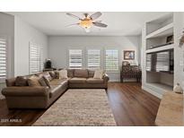 Cozy living room boasts hardwood floors, large windows, and a comfortable leather sofa at 20121 N 76Th St # 2006, Scottsdale, AZ 85255