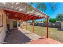 Covered patio has concrete floor, wood roof, and string lights to a grassy backyard at 2213 E Campbell Ave, Phoenix, AZ 85016