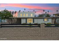 Charming single-Gathering home with a block fence and manicured front yard, set against a vibrant sunset sky at 2321 N 30Th St, Phoenix, AZ 85008