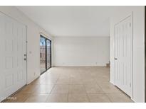 Bright living room featuring neutral tile flooring and sliding glass door to patio at 286 W Palomino Dr # 103, Chandler, AZ 85225