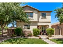 Charming two-story home with a well-manicured lawn, blooming bushes, and covered porch seating area at 3272 E Orchid Ln, Gilbert, AZ 85296