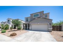 Two-story home features a desert landscape, concrete driveway, and a two-car garage at 33013 N Ash Tree Ln, San Tan Valley, AZ 85144
