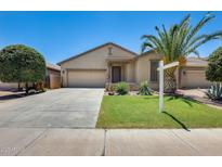 Charming single-story home featuring desert landscaping, green lawn, and a spacious two-car garage at 38125 W Santa Clara Ave, Maricopa, AZ 85138