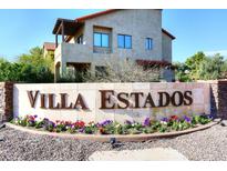 Beautiful community sign with flowers in front of two-story home in Villa Estados at 5998 N 78Th St # 222, Scottsdale, AZ 85250