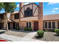 Charming townhome featuring brick facade, complemented by lush landscaping, creating a welcoming curb appeal at 7977 W Wacker Rd # 220, Peoria, AZ 85381