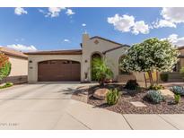 Charming single-story home featuring a well-manicured desert landscape and brown two car garage at 805 E La Palta St, Queen Creek, AZ 85140