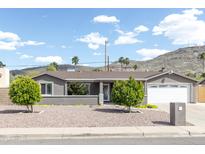 Charming single-story home with xeriscape landscaping and mature trees at 1445 W Wood Dr, Phoenix, AZ 85029