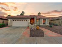 Charming home with a tile roof, desert landscaping and a two-car garage at 15695 W Earll Dr, Goodyear, AZ 85395
