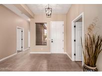 Inviting entryway with tile flooring, neutral walls, and a decorative light fixture at 16837 W Northampton Rd, Surprise, AZ 85374