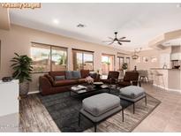 Spacious living room with modern furnishings, ceiling fan, and lots of natural light at 16837 W Northampton Rd, Surprise, AZ 85374