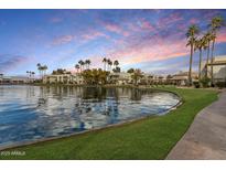 Scenic lakeside community featuring lush landscaping and palm trees against a vibrant sunset backdrop at 1825 W Ray Rd # 2132, Chandler, AZ 85224