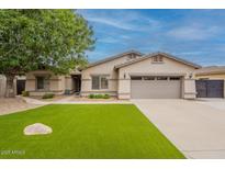 Charming single-story home with well-manicured lawn, mature tree, and two-car garage at 21231 E Nightingale Rd, Queen Creek, AZ 85142