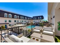 Relax on this outdoor balcony with lounge seating, overlooking the community pool on a beautiful sunny day at 4438 N 27Th St # 27, Phoenix, AZ 85016
