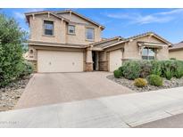 Beautiful two-story home with a brick driveway, three-car garage, and well-maintained landscaping at 5223 S Axiom --, Mesa, AZ 85212