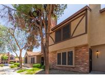 Charming two-story home with brick and stucco exterior, complemented by mature trees and lush landscaping at 7977 W Wacker Rd # 253, Peoria, AZ 85381