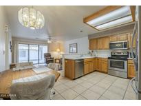 Well-lit kitchen featuring stainless steel appliances, wooden cabinetry, and a cozy dining area at 8261 E Keats Ave # 396, Mesa, AZ 85209