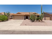 Charming single-story home with desert landscaping, including mature saguaro cacti and gravel groundcover at 9802 W Rockwood Dr, Peoria, AZ 85382