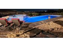 Inviting pool and spa with elegant tile work, illuminated by designer lighting in a well landscaped backyard overlooking the city lights at 11986 N 134Th Pl, Scottsdale, AZ 85259