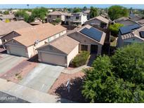 Charming single-story home featuring desert landscaping, a two-car garage, and solar panels for energy efficiency at 12934 W Voltaire Ave, El Mirage, AZ 85335