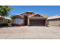 Charming single-story home with a well-maintained front yard and two car garage at 15642 N Naegel Dr, Surprise, AZ 85374