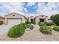Charming single story home featuring a two car garage, manicured bushes, and desert landscaping at 17192 W Hermosa Dr, Surprise, AZ 85387