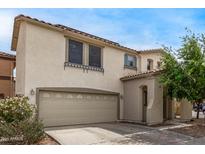 Charming two-story home with a neutral stucco exterior, tile roof, and a well-maintained two-car garage at 18563 W Fairway Dr, Surprise, AZ 85374