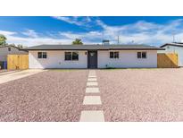 Charming home featuring a gray front door, white stucco, and rock landscaping at 2540 E Hartford Ave, Phoenix, AZ 85032