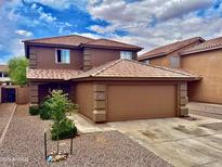 Two-story home with a two-car garage, a tile roof, and desert landscaping in the front yard at 272 S 228Th Ln, Buckeye, AZ 85326