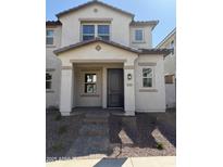 Charming home exterior featuring a stylish dark-colored front door and well-maintained landscaping at 2801 N Claire Dr, Buckeye, AZ 85396