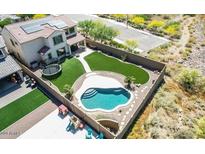 An aerial view of this home showcases a backyard oasis complete with a pool, grass and a play area at 4132 W Tunnel Mine Rd, New River, AZ 85087
